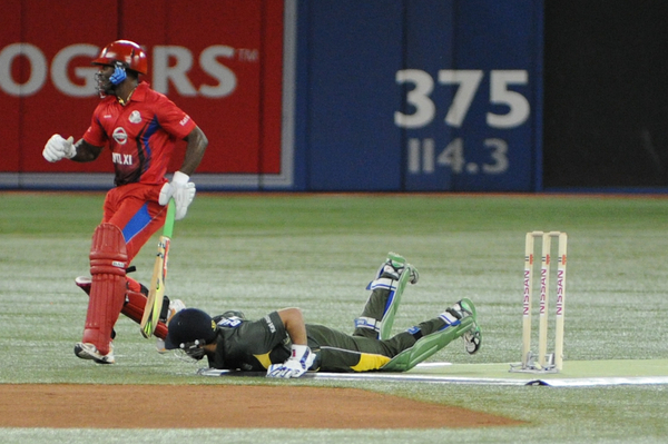 International XI batsman Devon Smith scrambles back as Asia/Canada wicket keeper lays on the ground after diving for a ball. Bagai was eventually able to stump Smith but not for the West Indies player hit for a match-high 69 runs to be named Man of the Match (Karan Vyas)